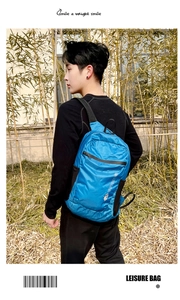 Outdoor view of a lightweight blue waterproof travel backpack with side pockets and logo