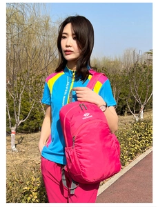 Outdoor view of lightweight rose pink waterproof folding backpack with brand logo and side mesh pocket