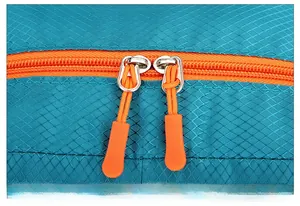 Détail du tissu ripstop bleu avec fermetures éclair orange sur le sac à dos de randonnée