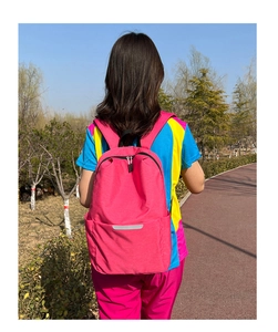 Vue extérieure d'un sac à dos rose réfléchissant léger avec bretelles réglables