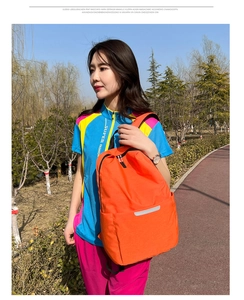 Détail du sac à dos léger orange vif avec bandes réfléchissantes argentées haute visibilité