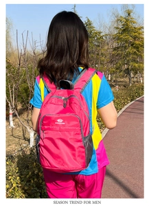 Outdoor view of lightweight water-resistant rose red backpack with mesh side pockets