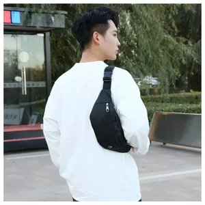 Vue en extérieur d'un sac banane noir en nylon porté par un mannequin en style urbain décontracté