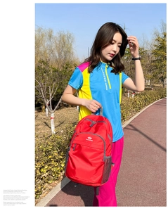 Detail of red VANAHEIMR outdoor backpack with side mesh pocket and zip compartments