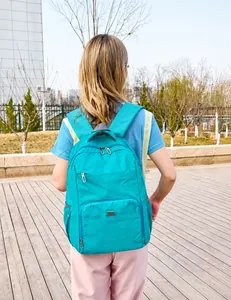 Detail of lake blue lightweight backpack with multiple pockets shown on a model outdoors