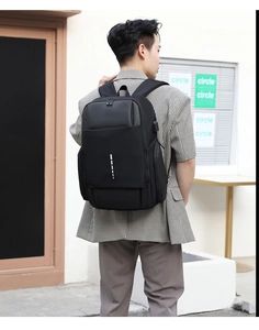 Detail view of the black business backpack featuring an external USB charging port and side pocket