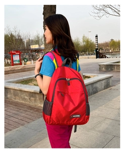 Detail view of water-resistant red nylon foldable backpack with side mesh pockets
