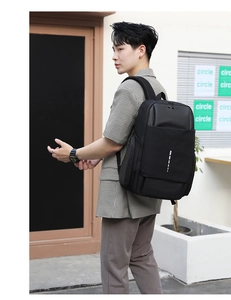 Side view of black business laptop backpack with white stripes on modern urban background
