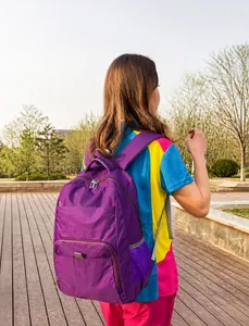 Purple multi-pocket backpack showing ergonomic strap design on a person outdoors