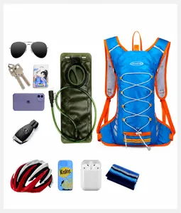 Flat lay of 12L blue cycling backpack with hydration bladder and outdoor gear items