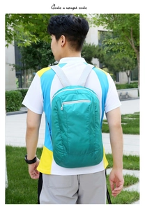 Close-up of lightweight foldable turquoise backpack with gray straps for outdoor use