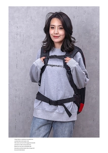 Front view of black and red hiking backpack with chest and waist straps on a female model