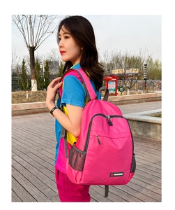 Outdoor shot of a rose pink lightweight foldable backpack with mesh side pockets