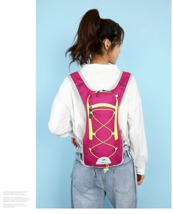 Close-up of lightweight cycling backpack in pink and lime green with reflective safety strips