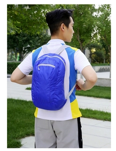 Blue lightweight foldable outdoor backpack shown on a person for size reference