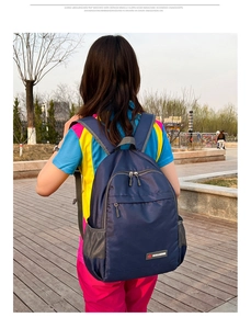 Detailed view of dark blue lightweight foldable backpack with front zipper pocket and side mesh