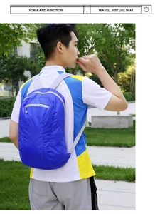 Lightweight blue foldable travel backpack worn outdoors with adjustable grey straps