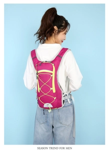 Detail view of pink cycling backpack with lime accents and cross bungee cord system