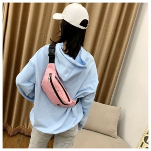 Sac banane en nylon rose avec sangle réglable et boucle en plastique porté par un mannequin