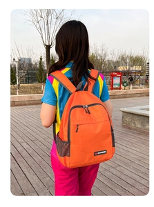 Detailed view of orange foldable nylon backpack with mesh side pocket and brand logo