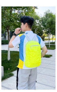 Outdoor view of a lightweight neon yellow folding backpack for sports and travel