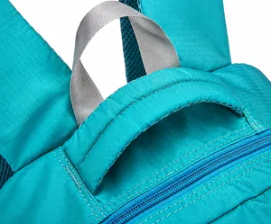 Detail of teal backpack featuring a reinforced padded handle and breathable mesh back