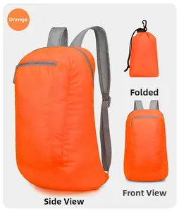 Detail of orange foldable backpack showing compact storage pouch and waterproof fabric