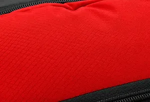 Macro shot of durable red ripstop fabric texture and black zipper on an outdoor backpack