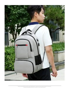 Détail du port de charge USB et du tissu Oxford sur le sac à dos gris multifonction