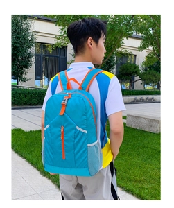 Zaino pieghevole blu leggero con cerniere arancioni e tasche a rete per l'esterno