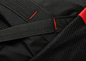 Detail of red reinforced triangular stitching on black durable waterproof outdoor backpack