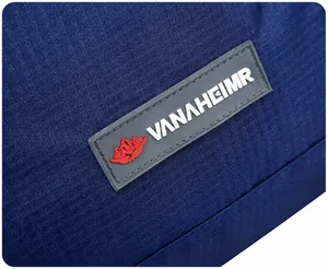 Detailed macro view of the black rubberized VANAHEIMR logo on blue waterproof nylon fabric