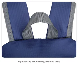 Detail of high-density gray handle and wide shoulder straps on a navy folding backpack