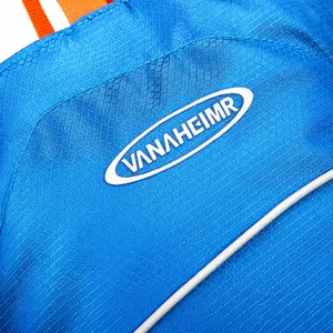 Macro detail of VANAHEIMR outdoor backpack featuring blue ripstop nylon and orange webbing