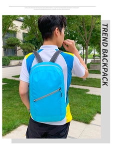 Blue foldable ultra-light travel backpack with breathable mesh straps shown on model