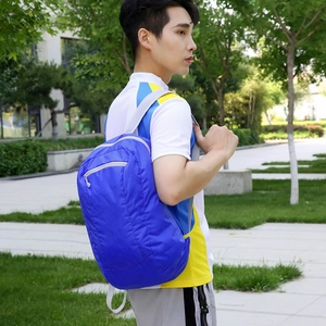 Lightweight blue foldable outdoor backpack for travel and hiking on a male model