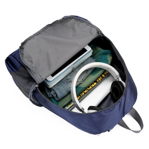 Foldable navy nylon backpack showing large capacity with laptop, headset, and books