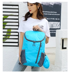 Close-up of bright blue waterproof foldable backpack with mesh pockets and storage pouch