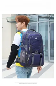 Male model wearing large deep blue and gray hiking backpack in an outdoor urban setting