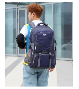 Detail of navy blue hiking backpack featuring multiple zippered layers and durable mesh pockets
