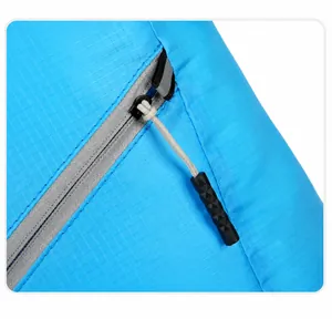 Detail van de grijze rits en blauwe ripstop nylon stof van de opvouwbare reisrugzak