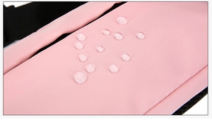 Primo piano del tessuto di tela rosa impermeabile con gocce d'acqua sulla superficie