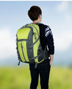 Zijaanzicht van een ergonomische groene outdoor wandelrugzak op een model buiten