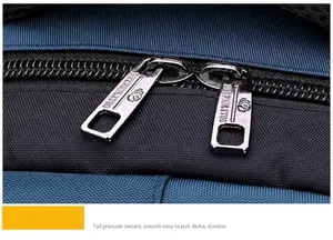 Macro detail of high-quality dual metal zippers on a navy blue woven outdoor backpack