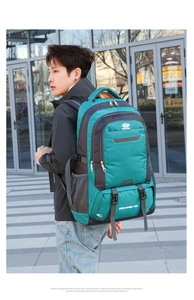 Asian male model wearing a 60L teal and grey waterproof hiking backpack outdoors