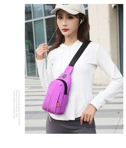Detail view of purple nylon chest bag with orange zipper and adjustable shoulder strap