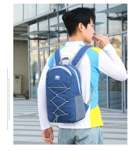 Detail view of navy blue foldable backpack showing side mesh pocket and elastic bungee cord
