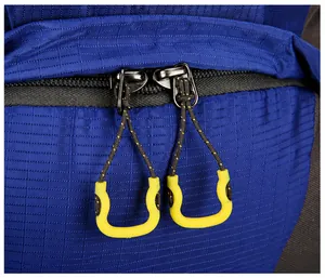 Close-up of durable two-way zippers with yellow non-slip pulls on the blue outdoor backpack