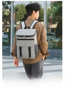 Model wearing gray insulated backpack with side mesh pockets in an outdoor setting