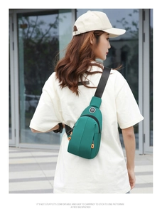 Outdoor crossbody bag in forest green waterproof nylon fabric on model backdrop